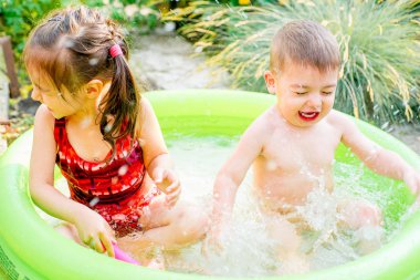 Şişme bebek havuzunda oynayan çocuk. Çocuklar yüzmek ve splash