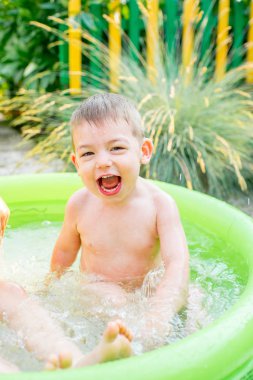 Şişme bebek havuzunda oynayan çocuk. Çocuklar yüzmek ve splash