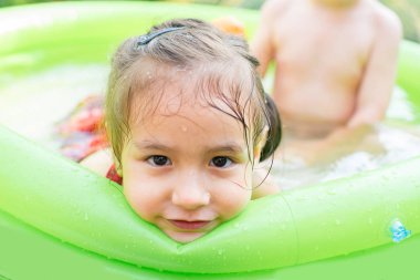Şişme bebek havuzunda oynayan çocuk. Çocuklar yüzmek ve splash