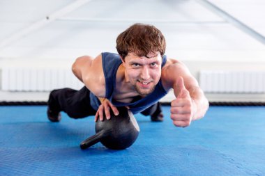 Bir spor salonunda CrossFit egzersiz yapan genç kaslı erkek