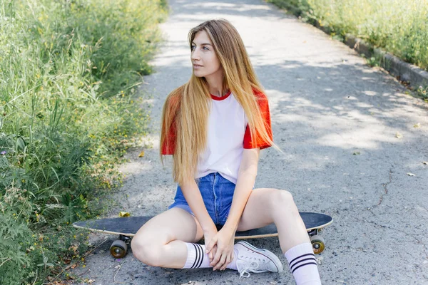 Krásný bruslař žena na koni na její longboard v městě — Stock fotografie