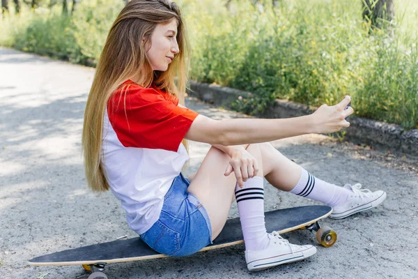 Belle patineuse femme chevauchant sur son longboard dans la ville — Photo