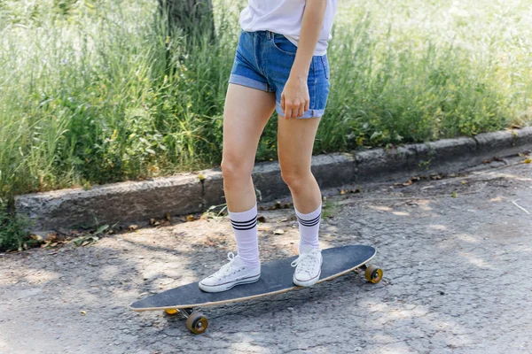 街で彼女のロングボードに乗って美しいスケーター女性 — ストック写真