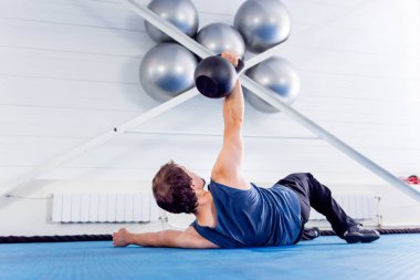 Bir spor salonunda CrossFit egzersiz yapan genç kaslı erkek