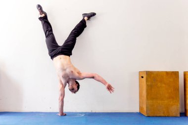 Bir spor salonunda CrossFit egzersiz yapan genç kaslı erkek