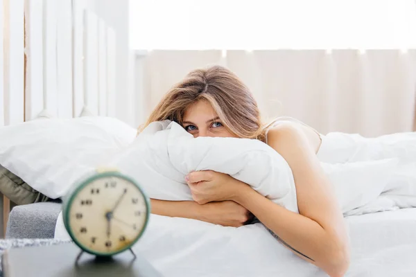 Young woman turns off the alarm clock in the morning — Stock Photo, Image