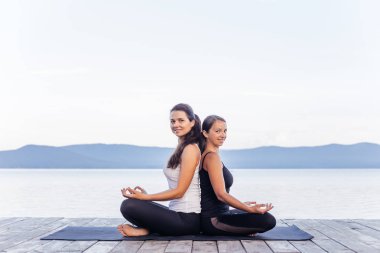 Pratik yoga bir göl kenarında genç çekici gülümseyen kadın