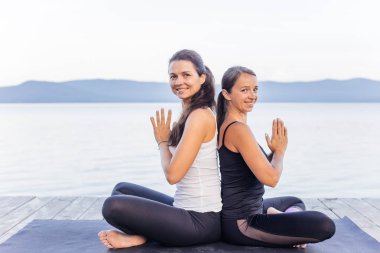 Pratik yoga bir göl kenarında genç çekici gülümseyen kadın