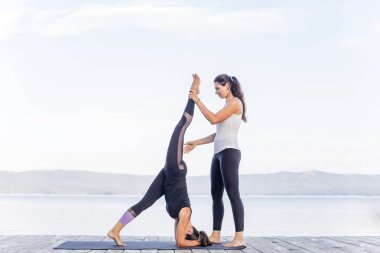 Pratik yoga bir göl kenarında genç çekici gülümseyen kadın