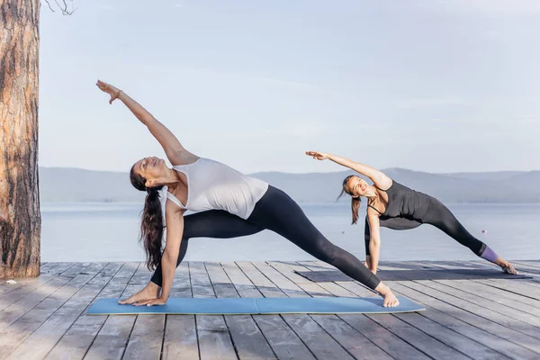 Pratik yoga bir göl kenarında genç çekici gülümseyen kadın