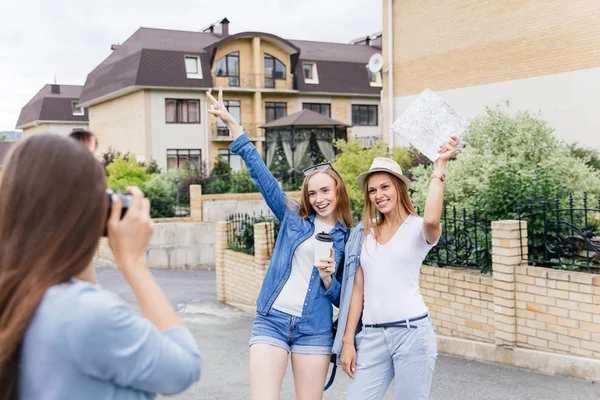 Mujeres que viajan en una ciudad usando mapa, bolsos y haciendo fotos — Foto de Stock