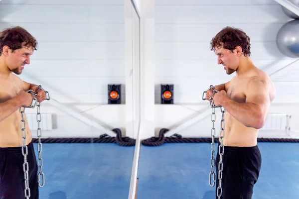 Joven musculoso haciendo ejercicios de crossfit en un gimnasio —  Fotos de Stock