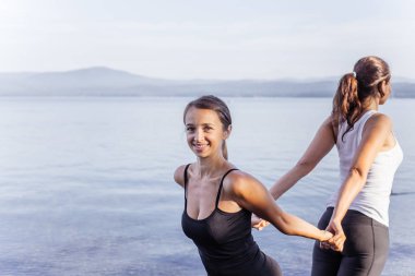 Pratik yoga bir göl kenarında genç çekici gülümseyen kadın