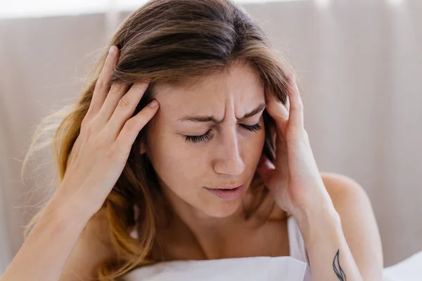 Um retrato de uma mulher que se estende na cama depois de acordar — Fotografia de Stock