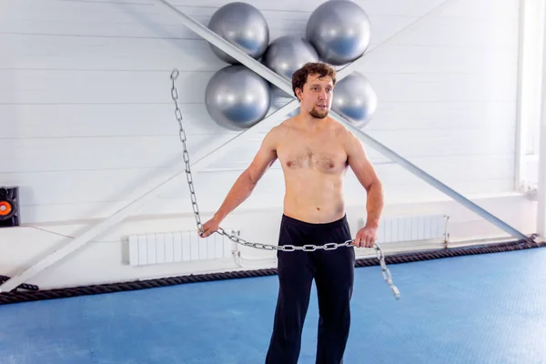 Crossfit gyakorlatok egy edzőteremben csinál izmos fiatalember — Stock Fotó
