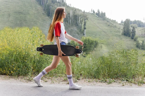 Kobieta piękna skater jazda na jej longboard w mieście — Zdjęcie stockowe