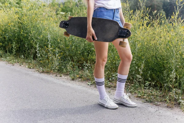 街で彼女のロングボードに乗って美しいスケーター女性 — ストック写真