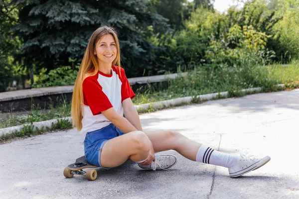 Mulher skatista bonita montando em seu longboard na cidade — Fotografia de Stock