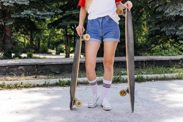 Mulher skatista bonita montando em seu longboard na cidade — Fotografia de Stock
