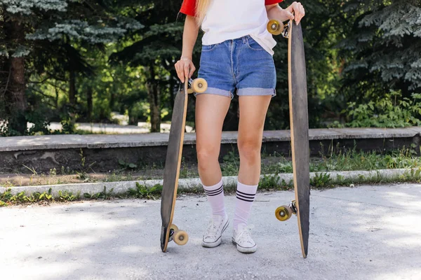 Hermosa mujer patinadora montando en su longboard en la ciudad — Foto de Stock