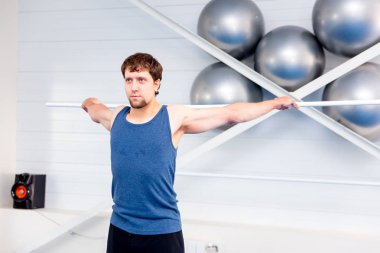 Bir spor salonunda CrossFit egzersiz yapan genç kaslı erkek