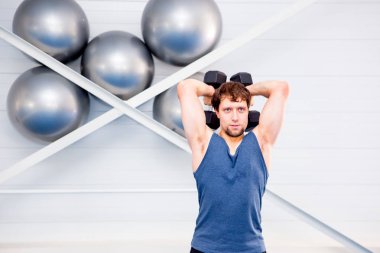 Bir spor salonunda CrossFit egzersiz yapan genç kaslı erkek