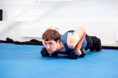 Bir spor salonunda CrossFit egzersiz yapan genç kaslı erkek