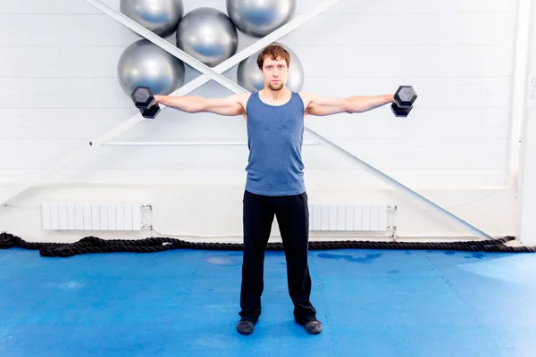 Joven musculoso haciendo ejercicios de crossfit en un gimnasio —  Fotos de Stock