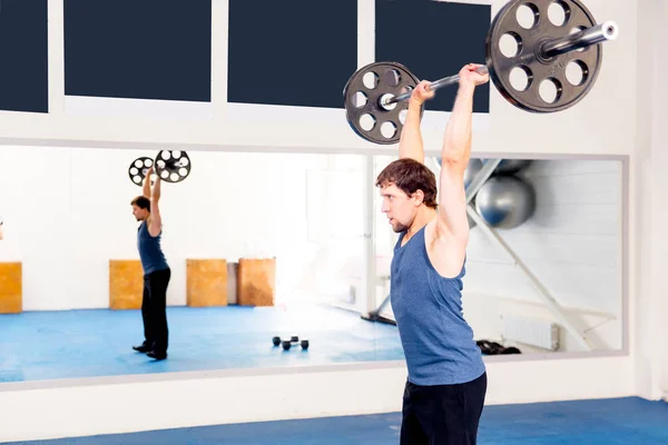 Молодий м'язистий чоловік робить кросфіт вправи в спортзалі — стокове фото