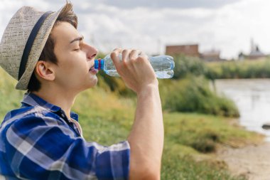 bir ara ve içme suyu şişeden alarak erkek uzun yürüyüşe çıkan kimse