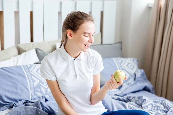 Leende friska flicka äta ett äpple och äter frukost — Stockfoto