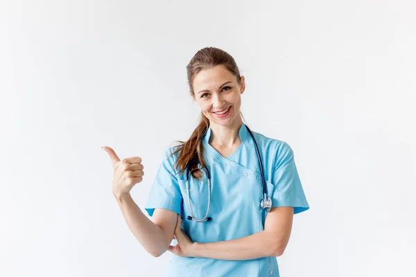 Портрет улыбающегося врача в форме на сером фоне — стоковое фото