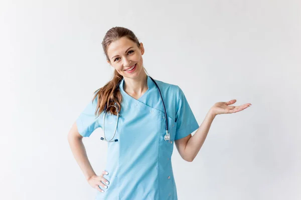 Retrato de alegre médico sonriente en uniforme sobre fondo gris — Foto de Stock