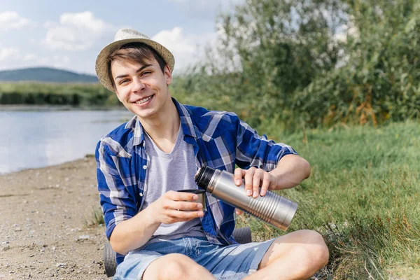 Excursionista está tomando un descanso y beber té o café de un termo — Foto de Stock