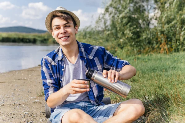 Excursionista está tomando un descanso y beber té o café de un termo — Foto de Stock