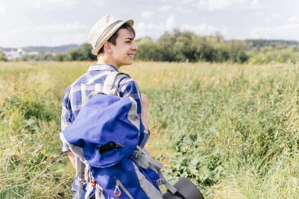 Mladý cestovatel chlap pěší turistika s batohem v přírodě — Stock fotografie