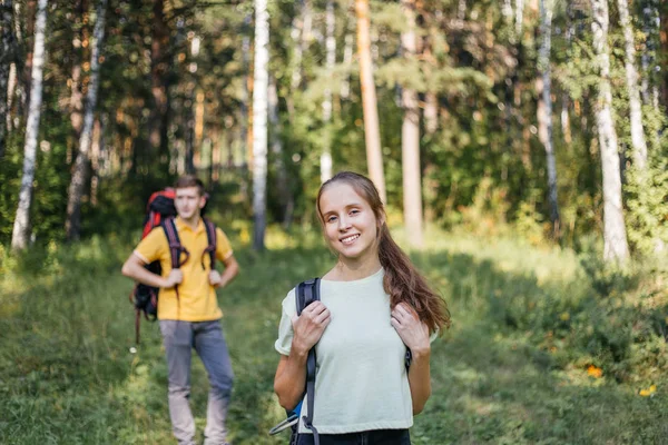 Casal de turistas com mochilas caminhadas em uma floresta — Fotografia de Stock