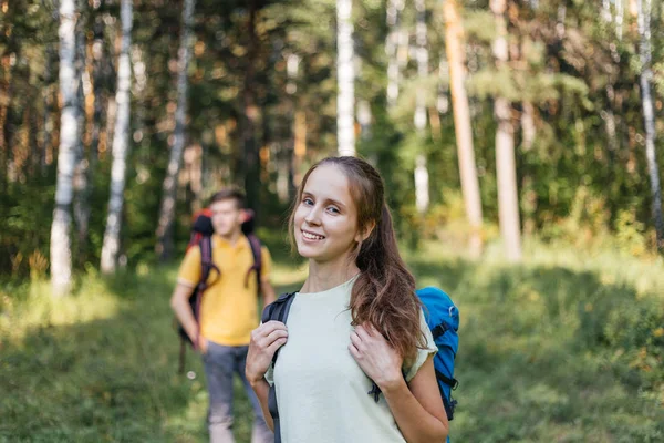 Para turystów z plecakami, wędrówki w lesie — Zdjęcie stockowe