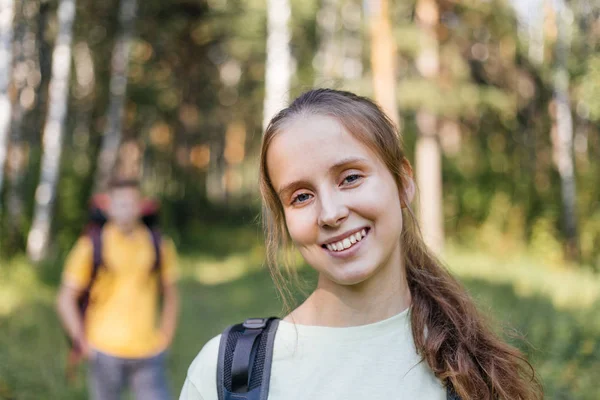 Couple de touristes avec sacs à dos randonnée dans une forêt — Photo