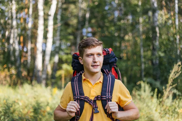 Couple of tourists with backpacks hiking in a forest — Stock Photo, Image