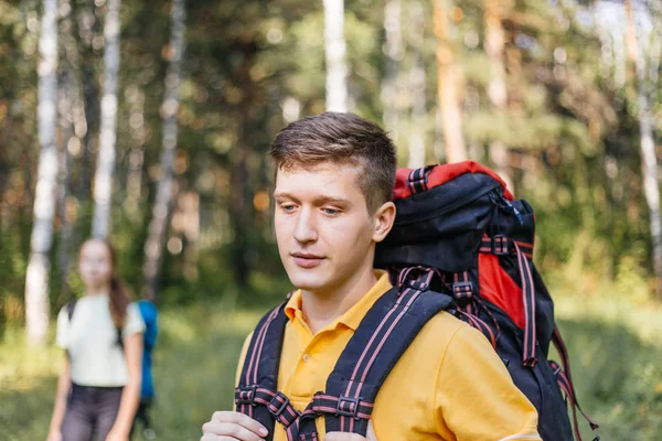 Casal de turistas com mochilas caminhadas em uma floresta — Fotografia de Stock