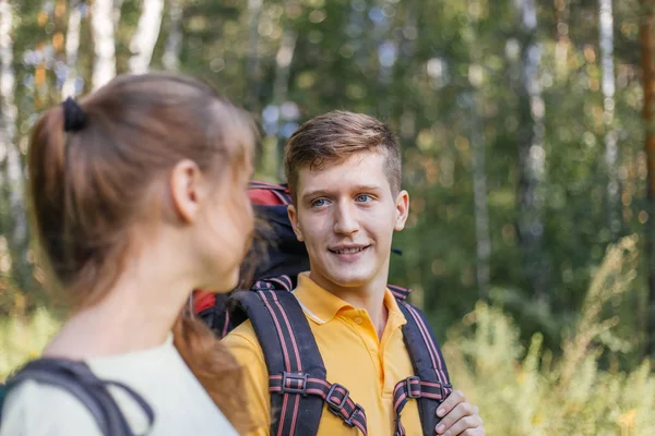 Casal de turistas com mochilas caminhadas em uma floresta — Fotografia de Stock