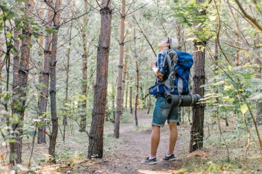 Genç yolcusu adam sırt çantası içinde doğa ile hiking