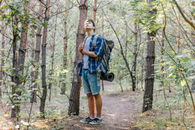 Genç yolcusu adam sırt çantası içinde doğa ile hiking