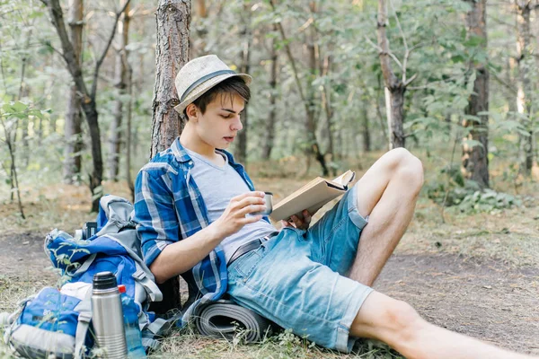 Joven caminante masculino está sentado y descansando en el bosque —  Fotos de Stock