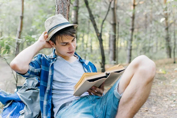 Joven caminante masculino está sentado y descansando en el bosque —  Fotos de Stock