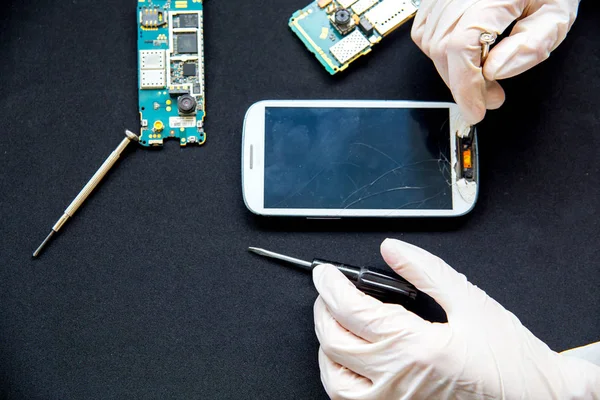 Servicio de reparación electrónica: el técnico está arreglando el teléfono celular roto — Foto de Stock