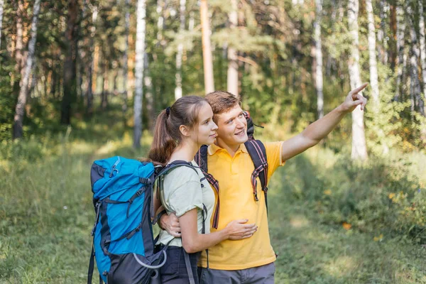 Pareja de turistas con mochilas de senderismo en un bosque —  Fotos de Stock