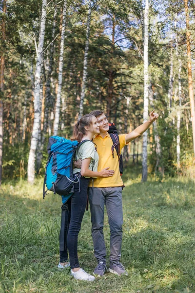Casal de turistas com mochilas caminhadas em uma floresta — Fotografia de Stock