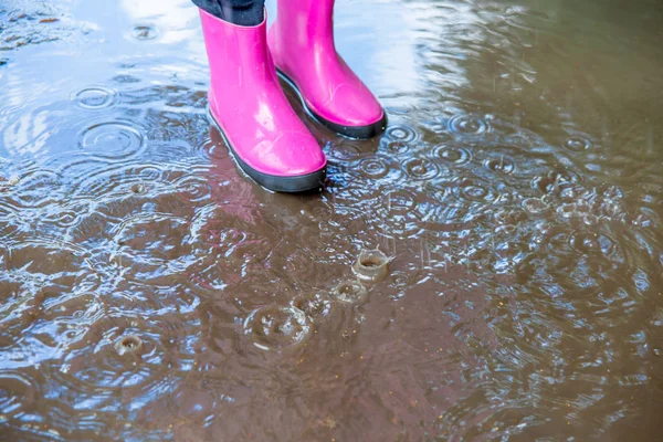 Žena v holínkách a procházky v dešti pláštěnku — Stock fotografie